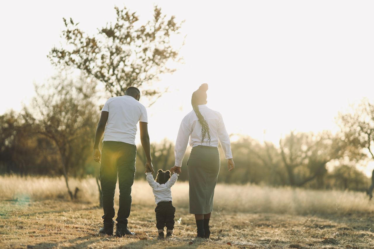 A family enjoys a sunny walk outdoors, creating memorable moments together.